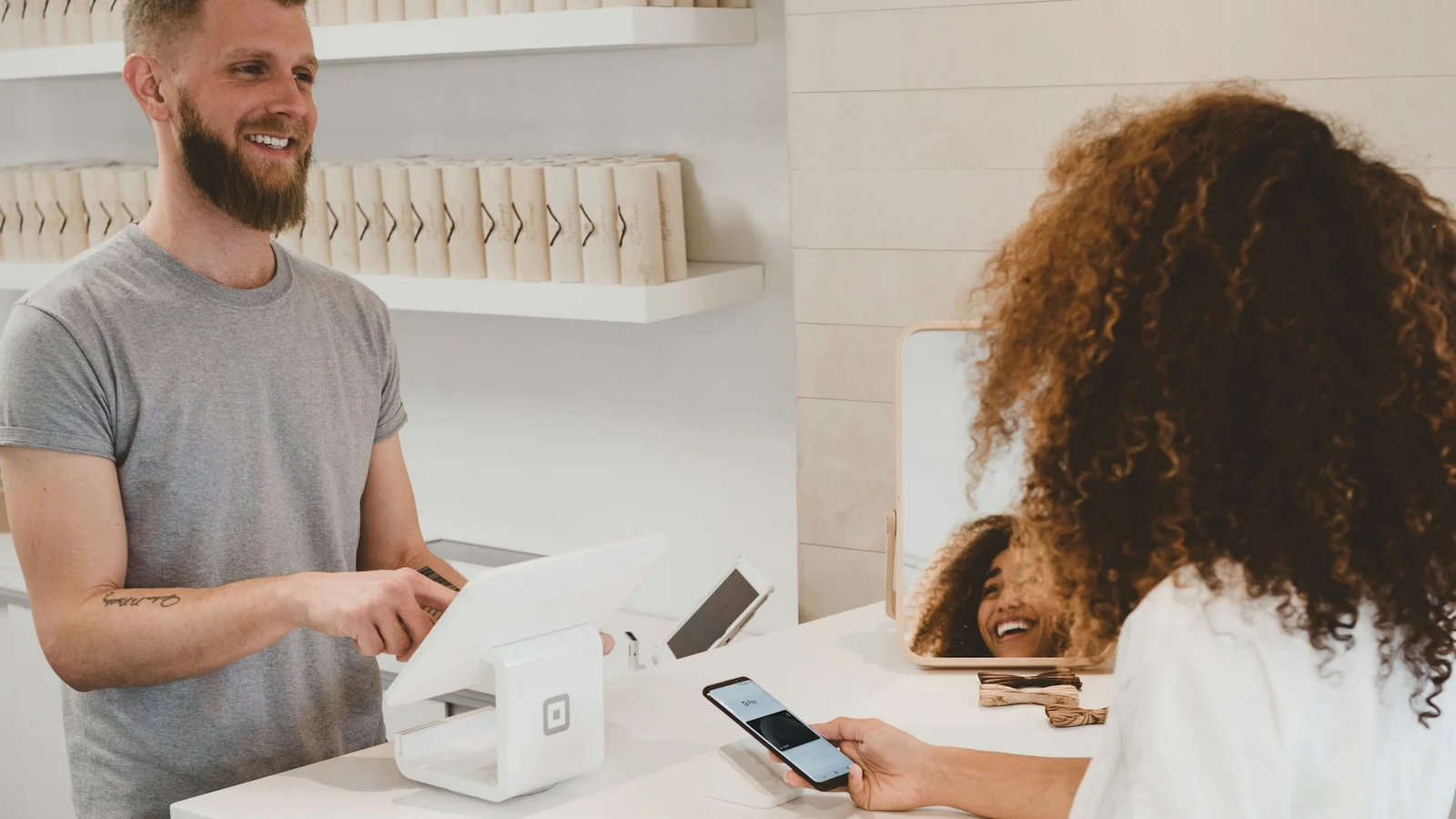 A retail team member assisting a customer at a point-of-sale counter
